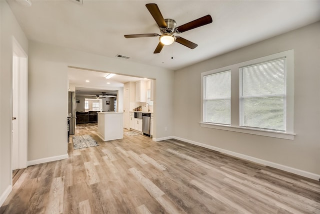 unfurnished living room featuring ceiling fan and light hardwood / wood-style flooring