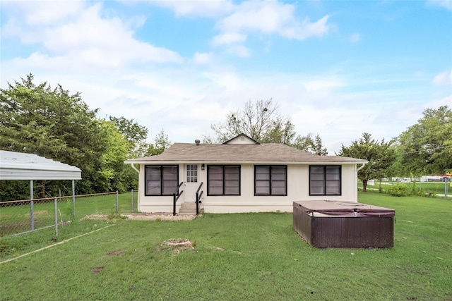 view of front of house with a hot tub and a front lawn