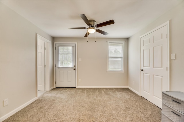 unfurnished room featuring light colored carpet and ceiling fan