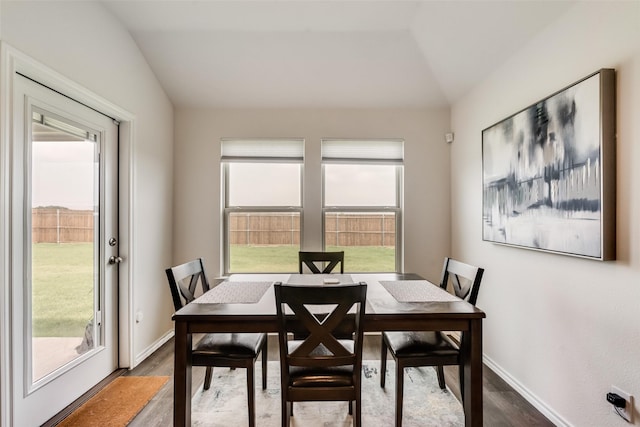 dining space featuring lofted ceiling, dark hardwood / wood-style floors, and a healthy amount of sunlight