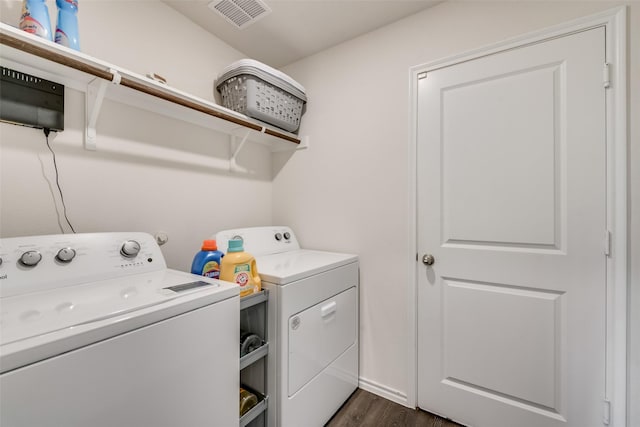 clothes washing area with dark hardwood / wood-style flooring and separate washer and dryer