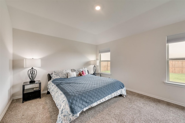 bedroom with multiple windows and light carpet