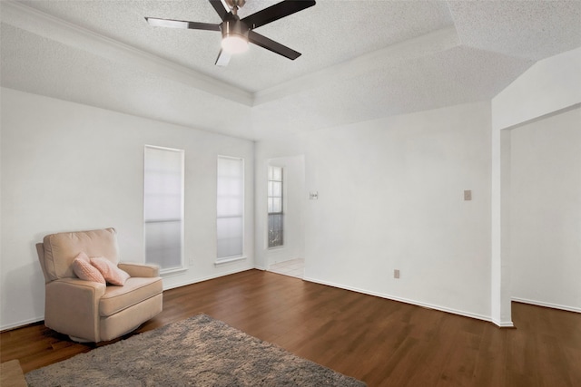 unfurnished room with ceiling fan, wood-type flooring, a tray ceiling, and a textured ceiling