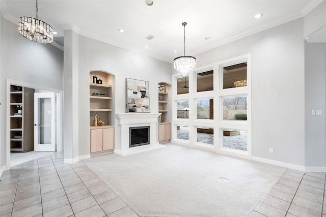 unfurnished living room featuring built in features, light colored carpet, a notable chandelier, and ornamental molding