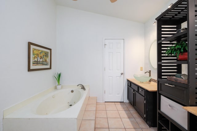 bathroom with vanity, vaulted ceiling, a washtub, and tile patterned floors