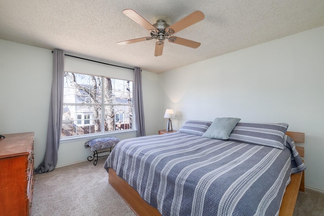 carpeted bedroom featuring ceiling fan and a textured ceiling