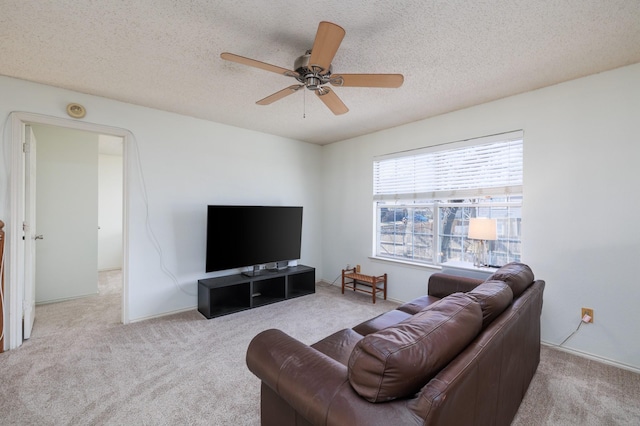 carpeted living room featuring ceiling fan and a textured ceiling