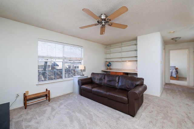 carpeted living room with ceiling fan and a textured ceiling