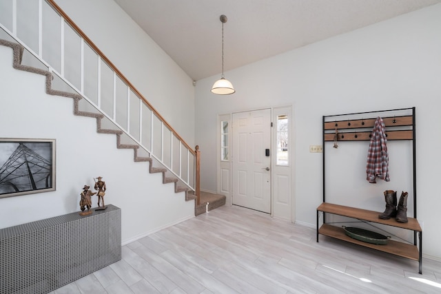 foyer featuring vaulted ceiling and light hardwood / wood-style flooring