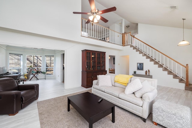 living room featuring ceiling fan, high vaulted ceiling, and light wood-type flooring