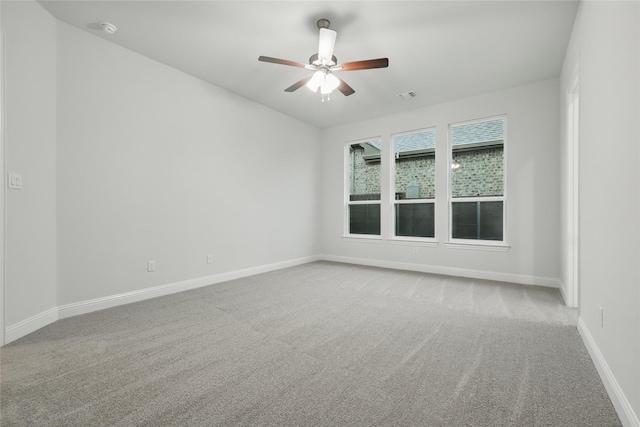 carpeted empty room with a ceiling fan, baseboards, visible vents, and vaulted ceiling