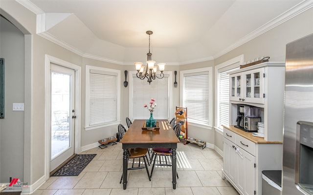 tiled dining space with a notable chandelier, a raised ceiling, and a wealth of natural light