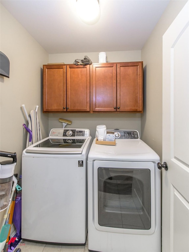 laundry room with washer and clothes dryer and cabinets