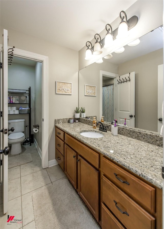 bathroom with tile patterned flooring, vanity, and toilet