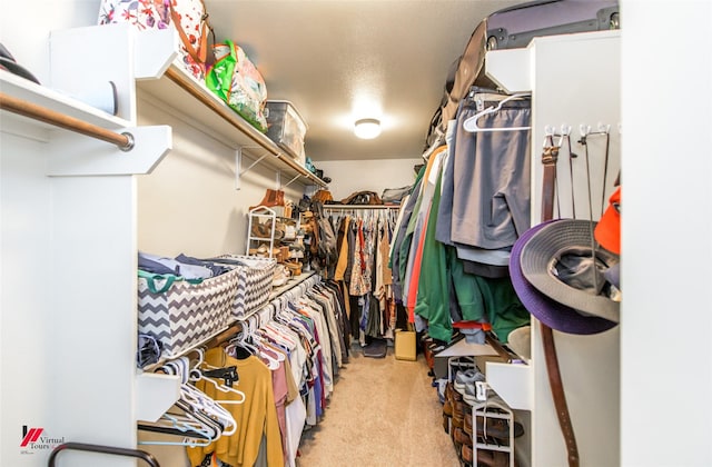 walk in closet featuring light carpet