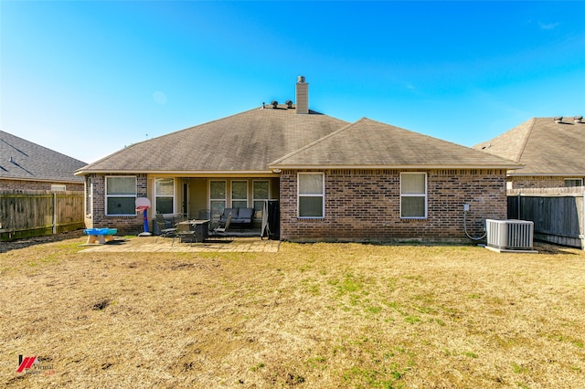 back of property featuring a lawn, a patio, and central air condition unit