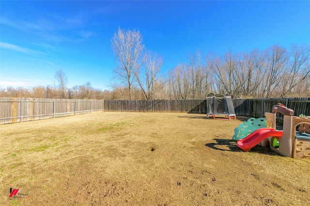 view of yard featuring a trampoline and a playground