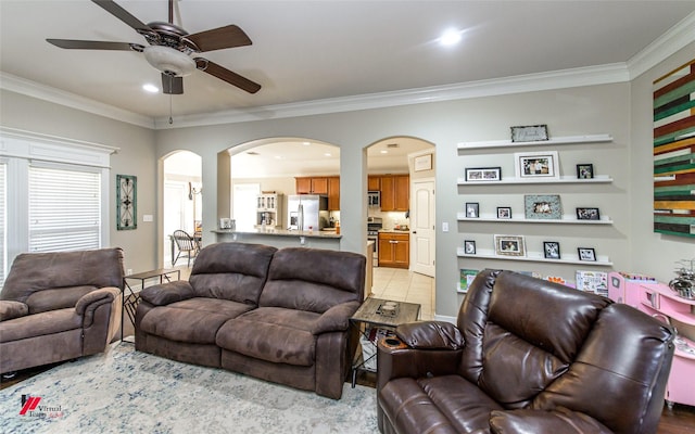 living room featuring light tile patterned flooring, ceiling fan, and ornamental molding