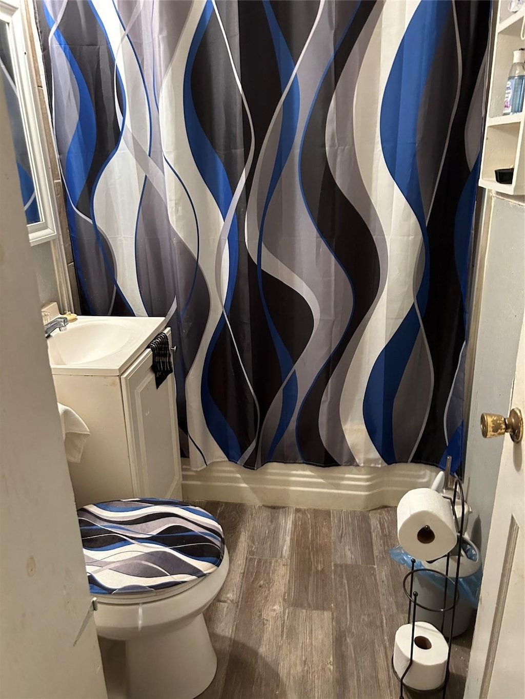 bathroom featuring hardwood / wood-style floors, a shower with curtain, sink, and toilet