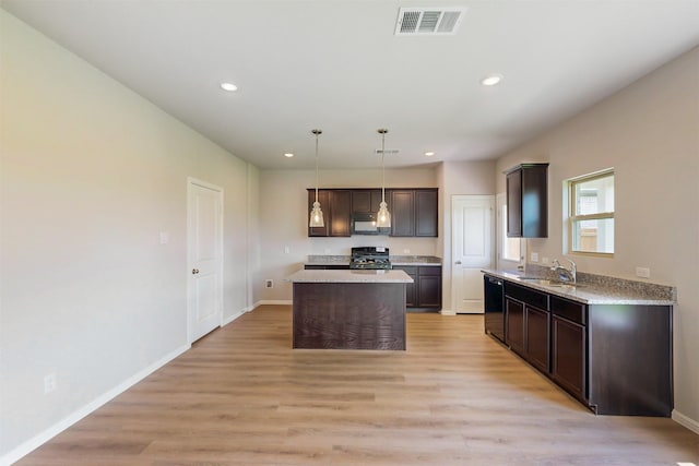 714 Gentle Bird Dr, Lavon, TX 75166 - kitchen with dark brown cabinets, black appliances, light wood finished floors, and visible vents