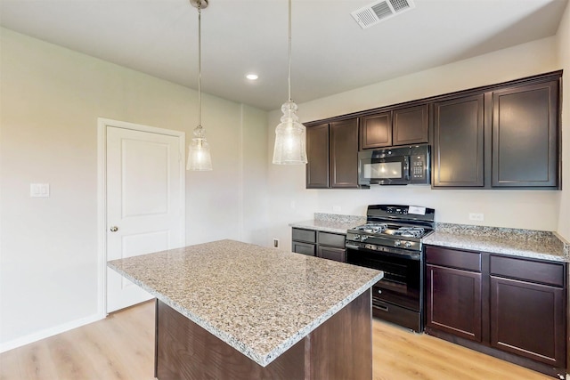 714 Gentle Bird Dr, Lavon, TX 75166 - kitchen featuring gas range, light wood-style flooring, visible vents, and black microwave