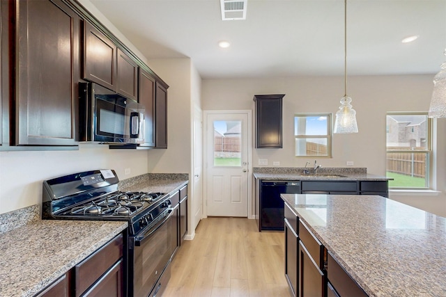 714 Gentle Bird Dr, Lavon, TX 75166 - kitchen with dark brown cabinets, light wood-style flooring, a sink, visible vents, and black appliances