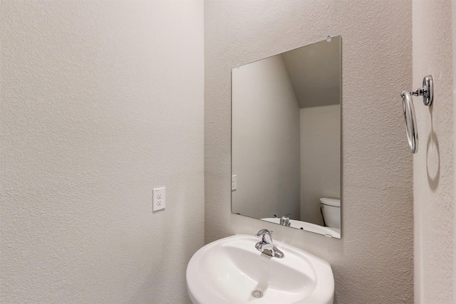 714 Gentle Bird Dr, Lavon, TX 75166 - bathroom with toilet, a sink, and a textured wall