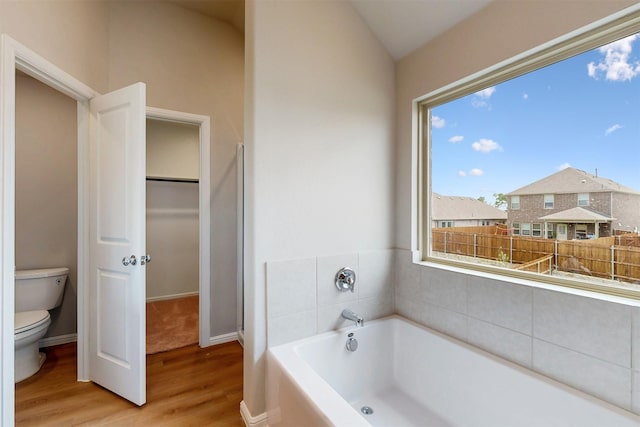 714 Gentle Bird Dr, Lavon, TX 75166 - bathroom featuring toilet, wood finished floors, a walk in closet, baseboards, and a bath