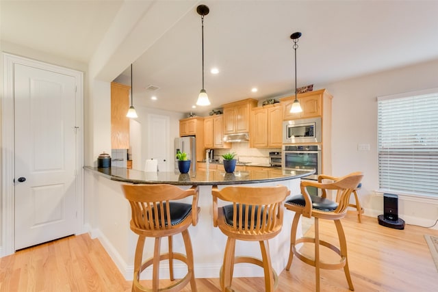 kitchen featuring pendant lighting, appliances with stainless steel finishes, dark stone countertops, decorative backsplash, and kitchen peninsula