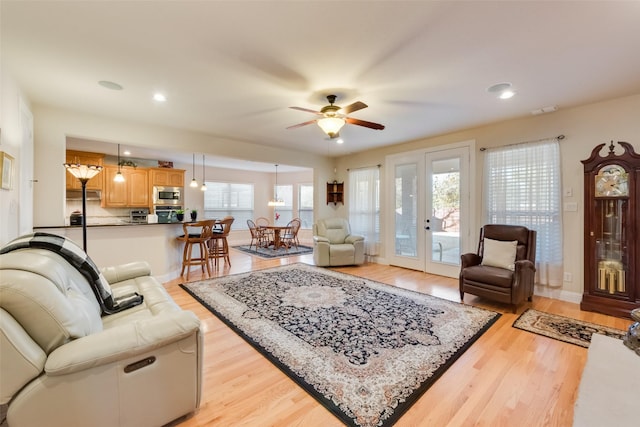 living room featuring light hardwood / wood-style floors and ceiling fan