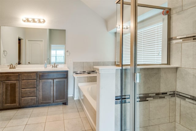 full bathroom featuring a garden tub, double vanity, vaulted ceiling, a sink, and tile patterned floors