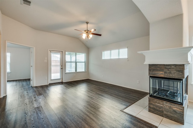 unfurnished living room with ceiling fan, visible vents, vaulted ceiling, and wood finished floors