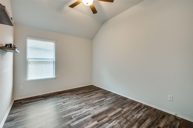 empty room featuring lofted ceiling, baseboards, a ceiling fan, and dark wood-style flooring