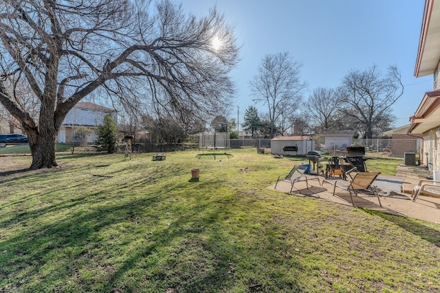 view of yard with a shed, a patio area, a trampoline, and central air condition unit