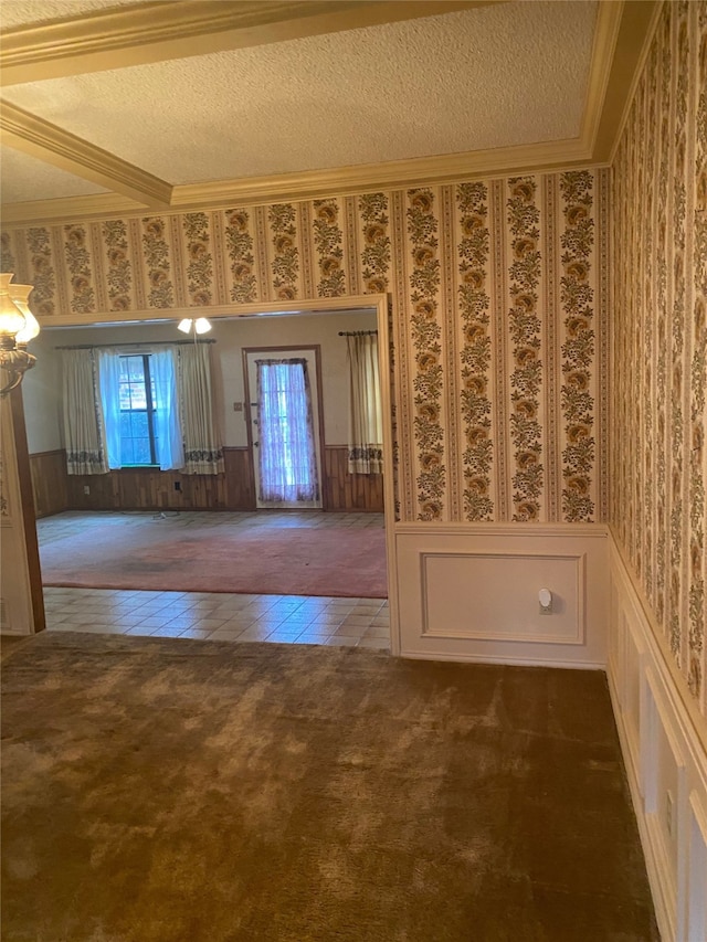 entryway featuring ornamental molding, dark carpet, and a textured ceiling