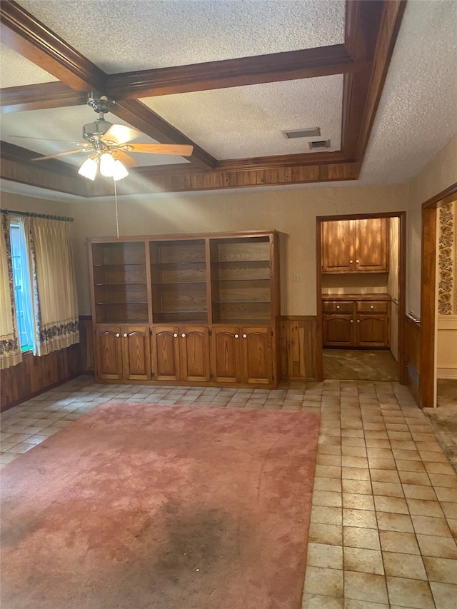 empty room featuring ceiling fan, light tile patterned flooring, a textured ceiling, and wood walls