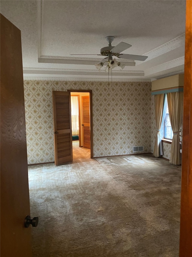 empty room featuring crown molding, carpet flooring, and a textured ceiling