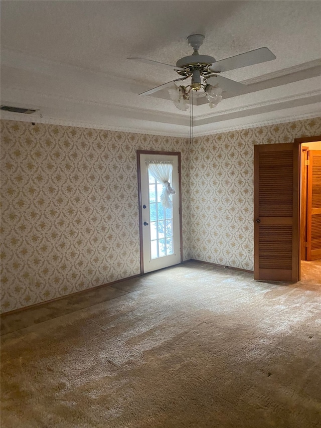 unfurnished room featuring ceiling fan, carpet, ornamental molding, and a textured ceiling