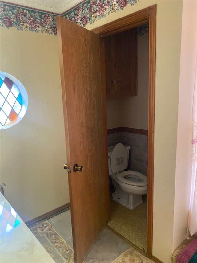 bathroom with tile walls and toilet