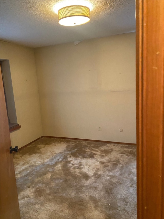 carpeted spare room with a textured ceiling