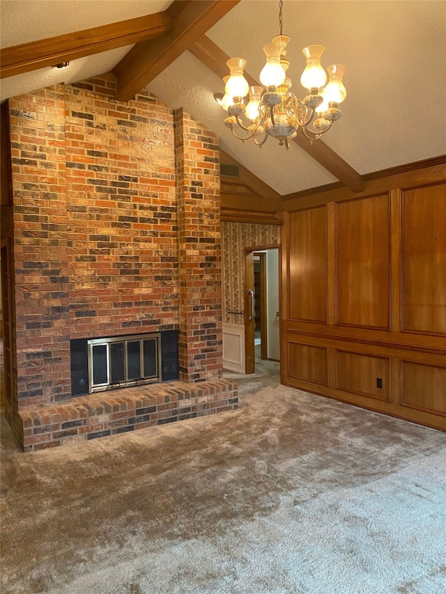 unfurnished living room featuring vaulted ceiling with beams, a brick fireplace, wooden walls, a notable chandelier, and carpet