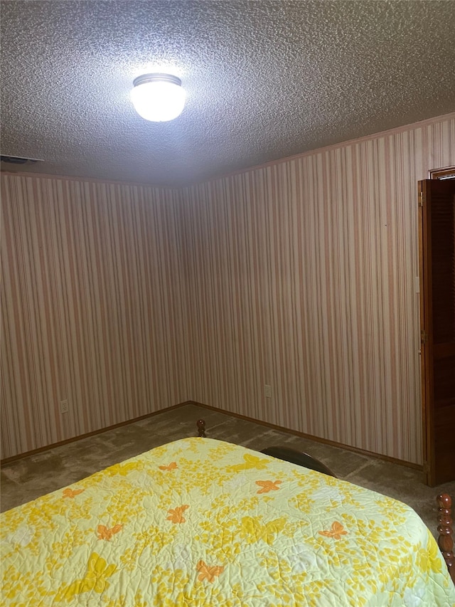 unfurnished bedroom with carpet and a textured ceiling