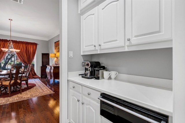 kitchen featuring ornamental molding, white cabinets, dishwashing machine, and dark wood-type flooring