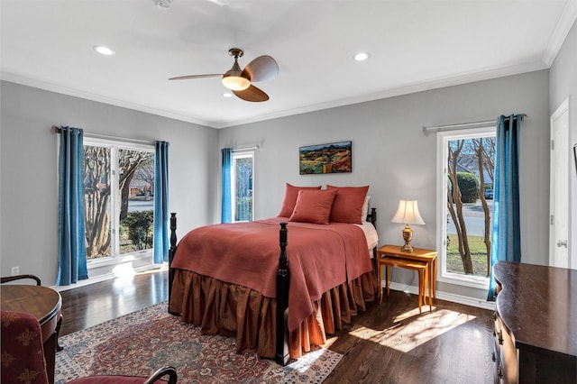 bedroom with baseboards, multiple windows, wood finished floors, and crown molding