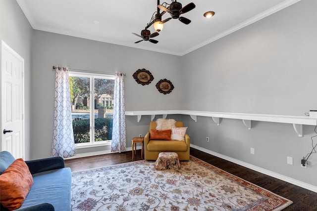 living area with crown molding, dark wood-type flooring, and ceiling fan