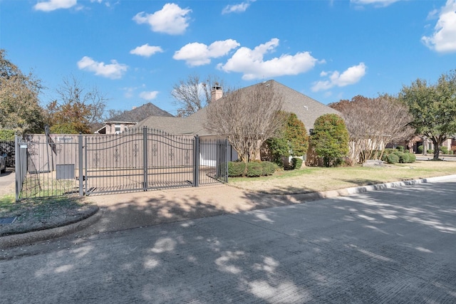 view of front facade featuring a gate, fence, and concrete driveway