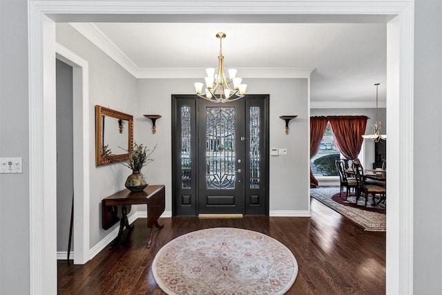 foyer with a chandelier, crown molding, baseboards, and wood finished floors