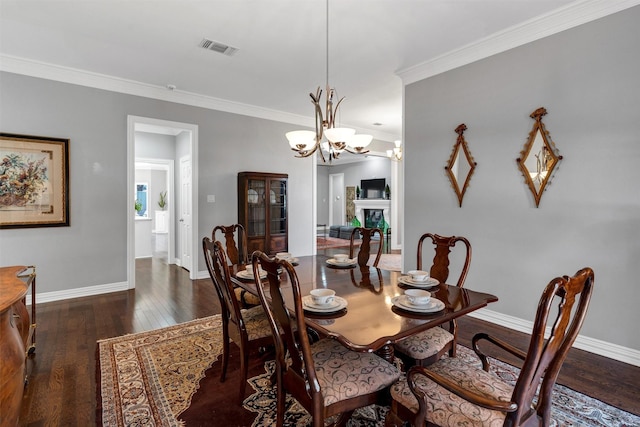 dining area featuring crown molding, a fireplace, baseboards, and dark wood-style flooring