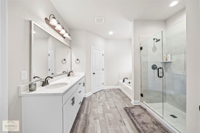 bathroom featuring vanity, independent shower and bath, and hardwood / wood-style floors