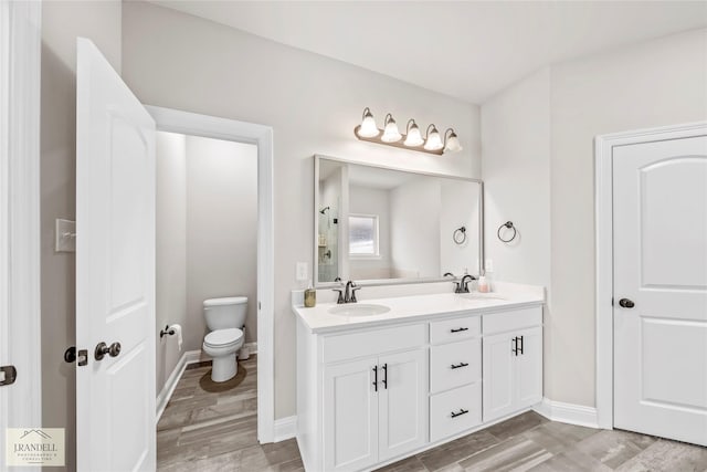 bathroom with vanity, toilet, and hardwood / wood-style floors